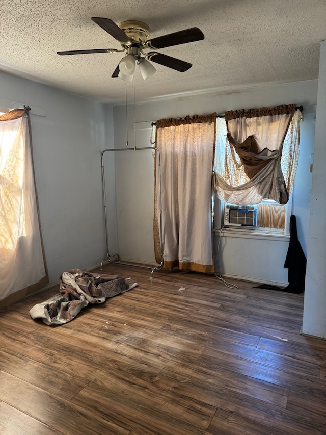 interior space with a textured ceiling and wood finished floors