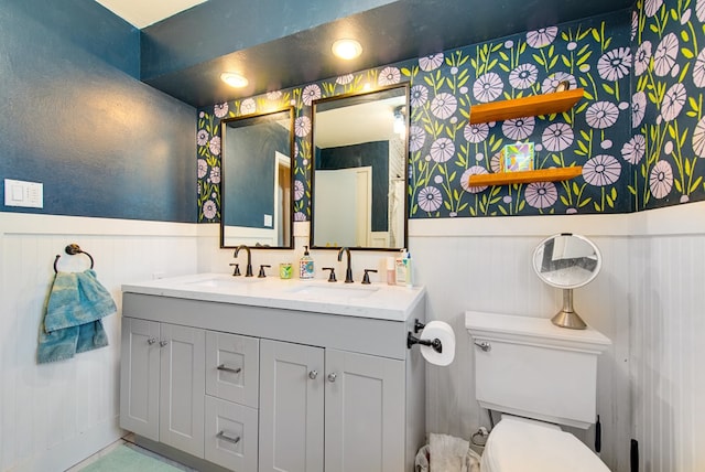 2817 W Shandon Ave, Midland, TX 79705 - bathroom with toilet, a wainscoted wall, and double vanity