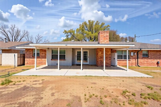 2817 W Shandon Ave, Midland, TX 79705 - rear view of property featuring a chimney, brick siding, board and batten siding, and a patio area