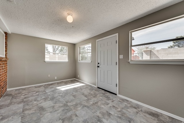 entryway featuring a textured ceiling, baseboards, and tile patterned floors