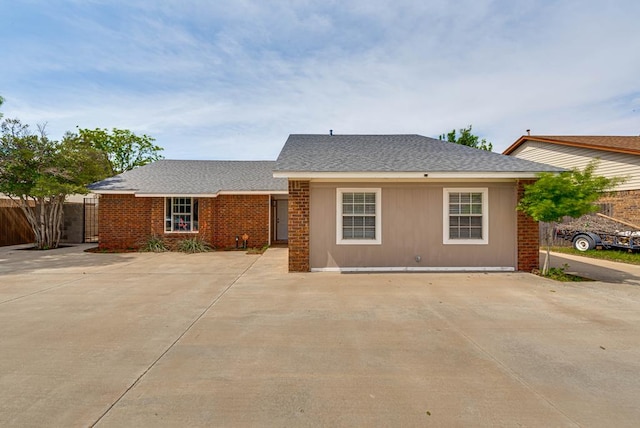 ranch-style house featuring fence and a shingled roof