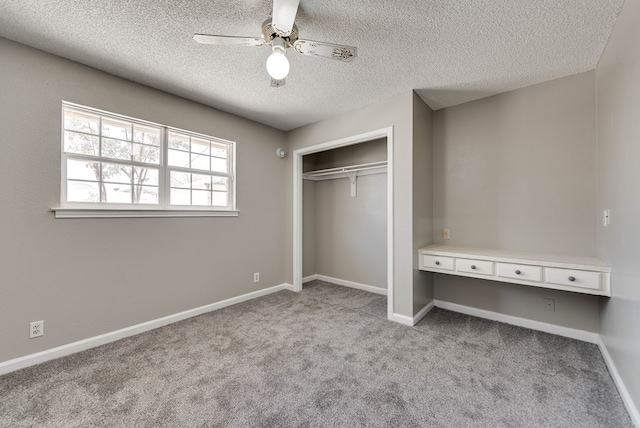 unfurnished bedroom featuring a textured ceiling, carpet floors, a closet, ceiling fan, and baseboards