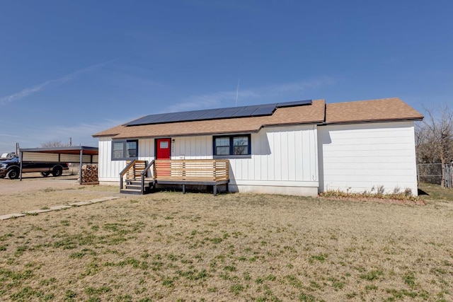 view of front facade with a front yard and solar panels