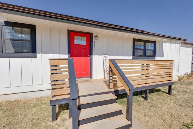 doorway to property featuring a lawn