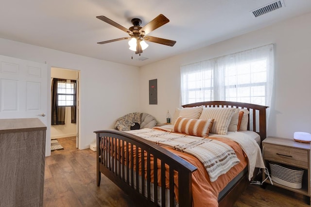 bedroom featuring ceiling fan, electric panel, and dark hardwood / wood-style flooring