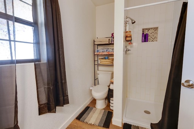 bathroom with toilet and a shower with shower curtain