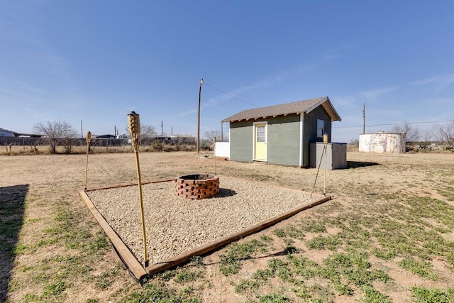 view of yard with a shed and an outdoor fire pit