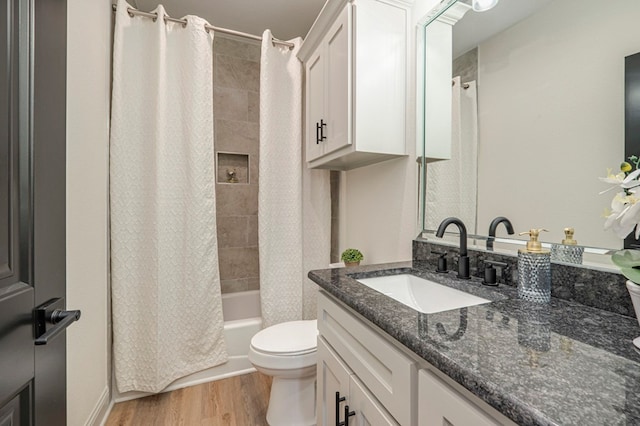 full bathroom with hardwood / wood-style floors, vanity, toilet, and shower / tub combo with curtain