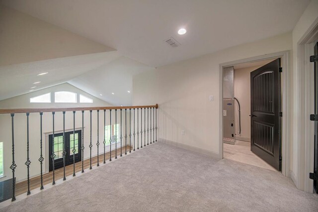 corridor featuring light carpet and lofted ceiling