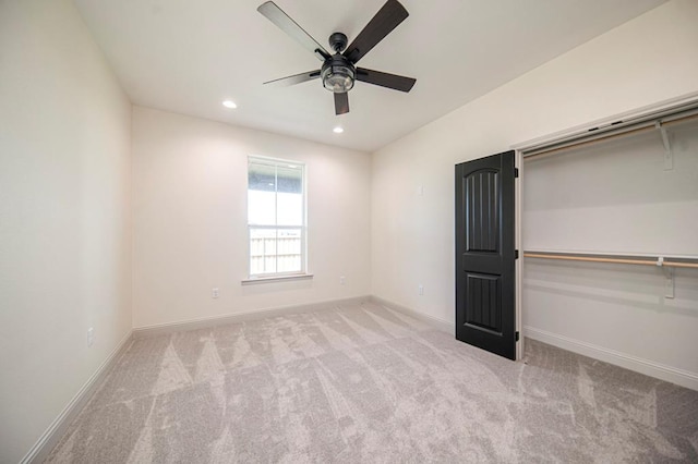 unfurnished bedroom with ceiling fan, light carpet, and a closet