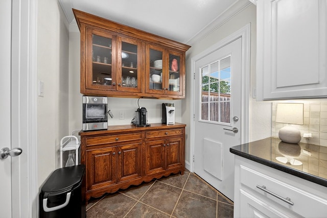 1602 Cimmaron Dr, Midland, TX 79705 - bar with ornamental molding, backsplash, and dark tile patterned floors
