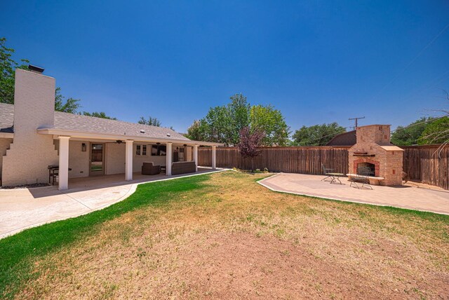 1602 Cimmaron Dr, Midland, TX 79705 - fenced backyard with an outdoor stone fireplace, a patio, and ceiling fan