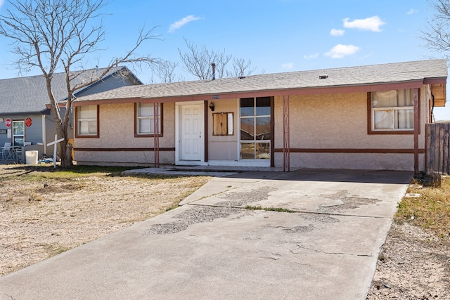 ranch-style home with a shingled roof and stucco siding