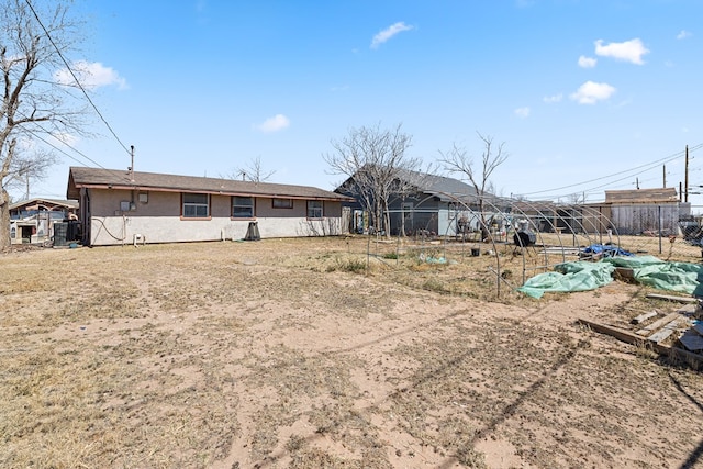 rear view of house with central AC unit and fence