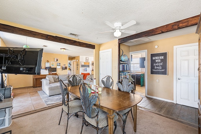 dining area featuring ceiling fan, beam ceiling, visible vents, and a textured ceiling