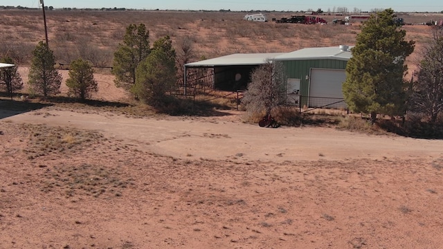 view of yard featuring a rural view, a garage, and an outdoor structure