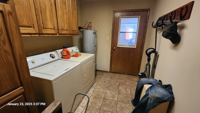 clothes washing area featuring electric water heater, washer and clothes dryer, cabinets, and light tile patterned flooring