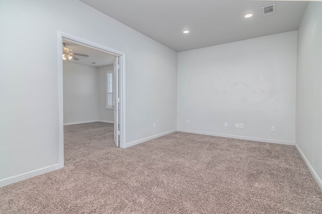 carpeted empty room featuring recessed lighting, visible vents, and baseboards