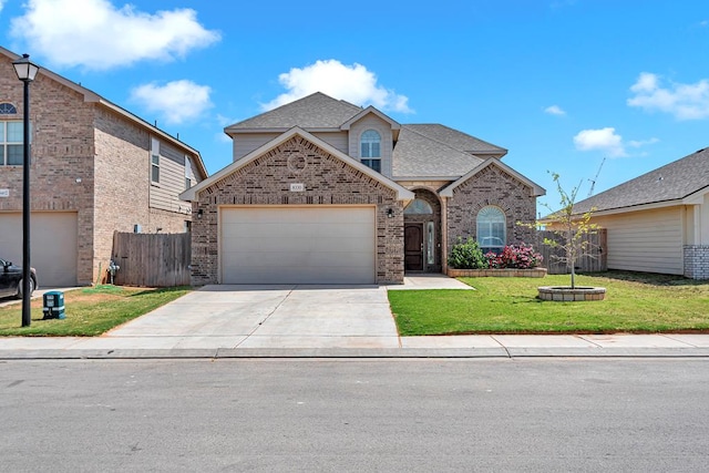 view of front of house featuring roof with shingles, concrete driveway, fence, a garage, and a front yard