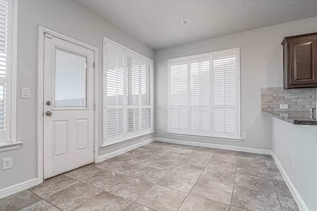 unfurnished dining area featuring baseboards