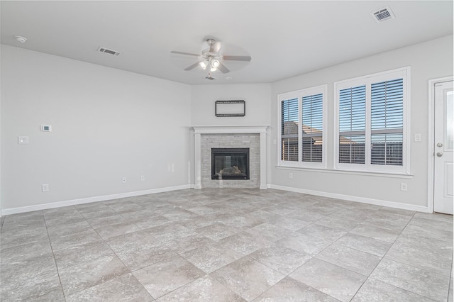 unfurnished living room featuring a glass covered fireplace, visible vents, ceiling fan, and baseboards