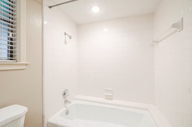 full bath featuring shower / bath combination, toilet, and a textured ceiling