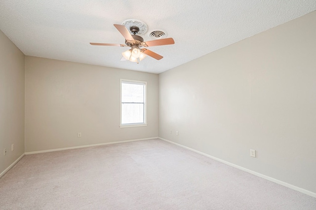 unfurnished room featuring a ceiling fan, light colored carpet, a textured ceiling, and baseboards