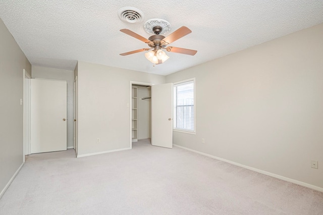 unfurnished bedroom featuring baseboards, visible vents, a textured ceiling, and light colored carpet