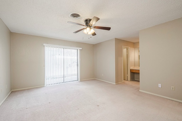 spare room featuring visible vents, light carpet, ceiling fan, a textured ceiling, and baseboards