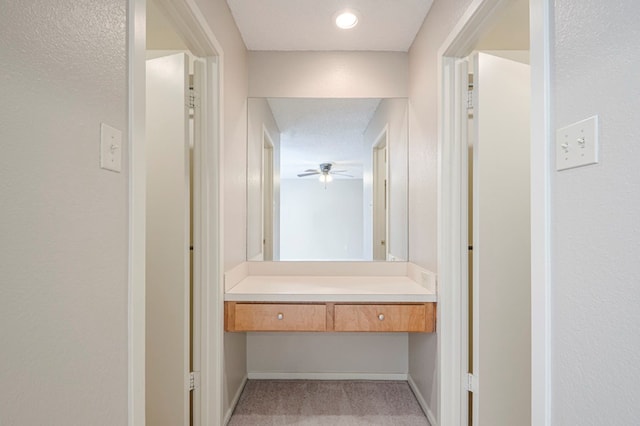 bathroom featuring a textured wall, baseboards, a textured ceiling, and vanity