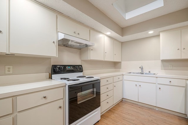 kitchen with electric stove, light countertops, light wood-type flooring, under cabinet range hood, and a sink