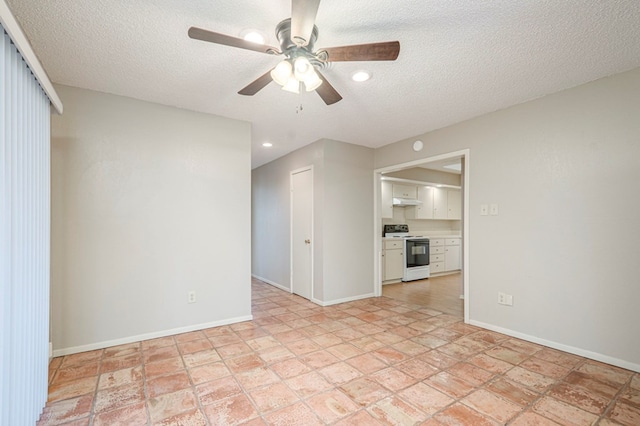 unfurnished room with a ceiling fan, a textured ceiling, and baseboards