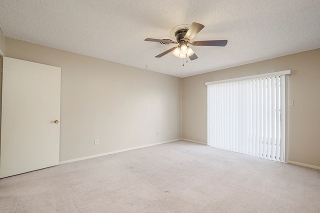 unfurnished room featuring ceiling fan, baseboards, a textured ceiling, and light colored carpet