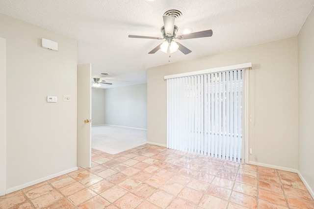 unfurnished room with a textured ceiling, a ceiling fan, and baseboards