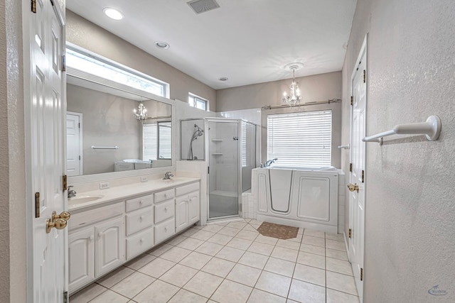 bathroom featuring double vanity, a stall shower, a sink, a chandelier, and tile patterned floors