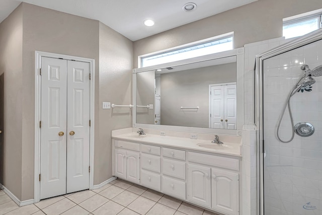 full bath featuring a closet, double vanity, a sink, and tile patterned floors