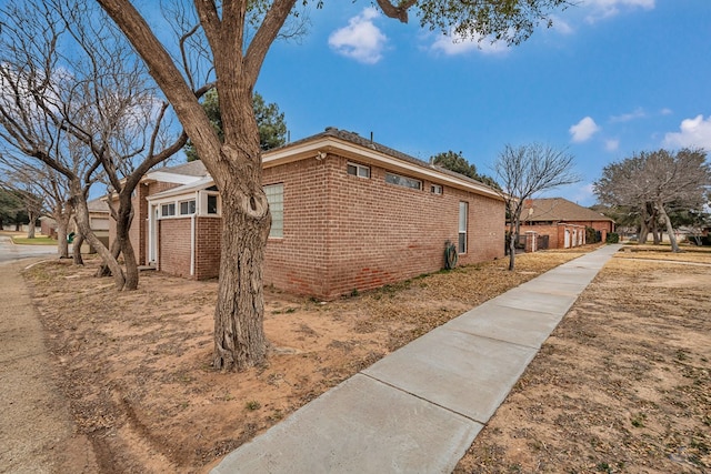 view of side of home featuring brick siding