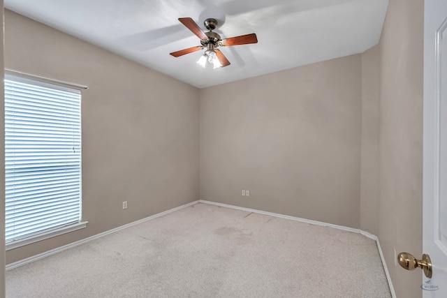 empty room featuring a healthy amount of sunlight, baseboards, a ceiling fan, and light colored carpet