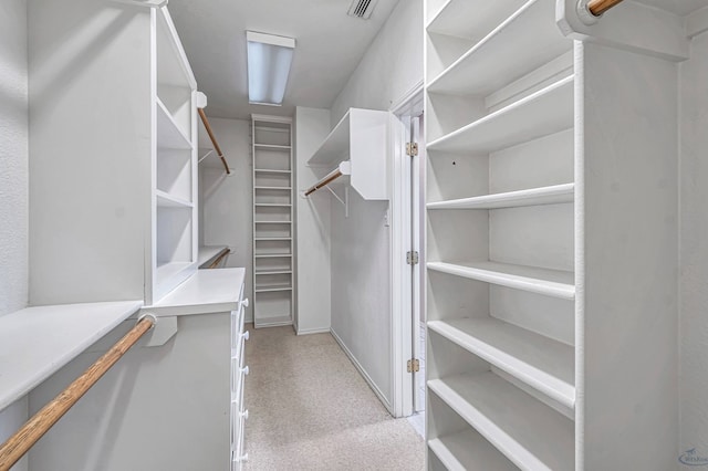 walk in closet with visible vents and light carpet