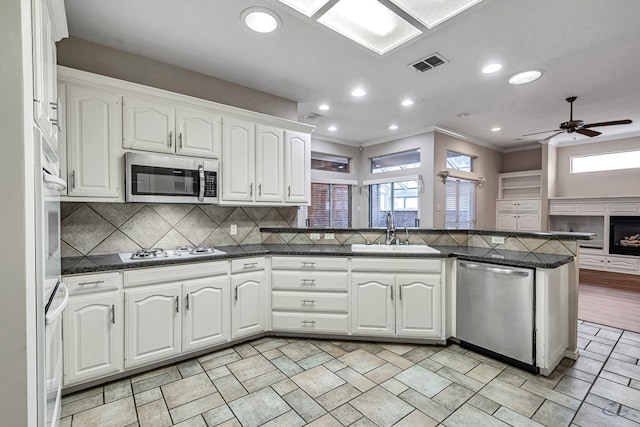 kitchen featuring appliances with stainless steel finishes, white cabinets, and a sink