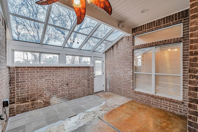 unfurnished sunroom with vaulted ceiling with beams