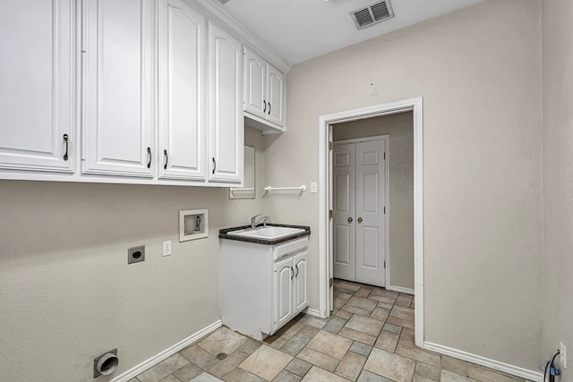 laundry room featuring cabinet space, visible vents, a sink, and baseboards