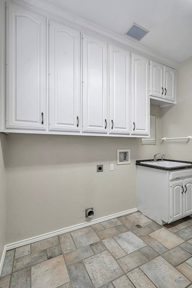 laundry room with a sink, baseboards, visible vents, and stone tile flooring