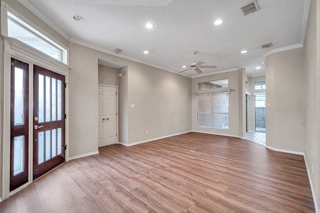 foyer featuring light wood-style flooring, visible vents, baseboards, and ornamental molding