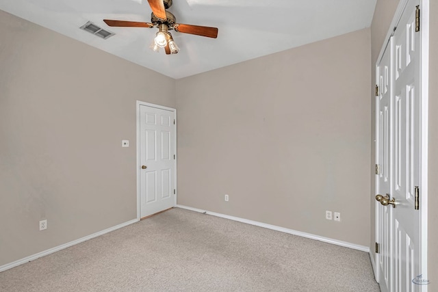 unfurnished room with light carpet, ceiling fan, visible vents, and baseboards