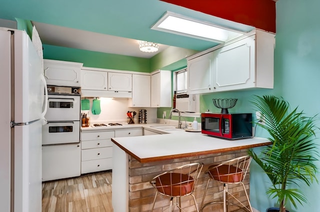 600 Liddon Unit 78, Midland, TX 79705 - kitchen featuring white appliances, a sink, a peninsula, and white cabinets