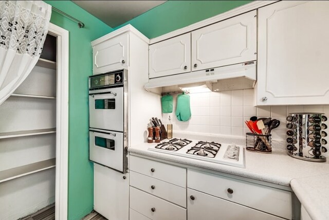 600 Liddon Unit 78, Midland, TX 79705 - kitchen with white appliances, under cabinet range hood, backsplash, light countertops, and white cabinets
