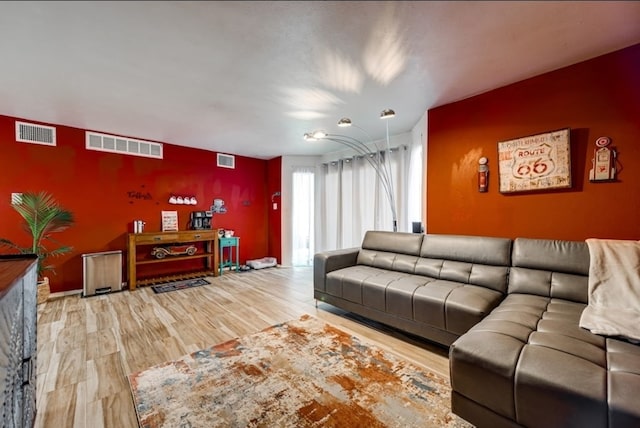 600 Liddon Unit 78, Midland, TX 79705 - living room featuring an accent wall and wood finished floors