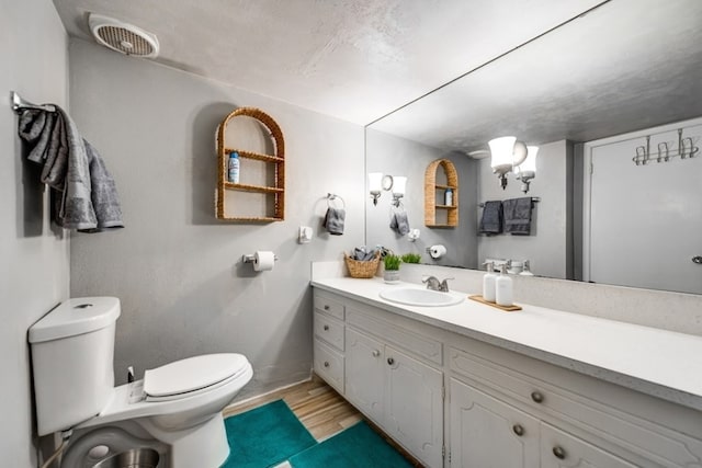 600 Liddon Unit 78, Midland, TX 79705 - bathroom featuring toilet, vanity, wood finished floors, and baseboards
