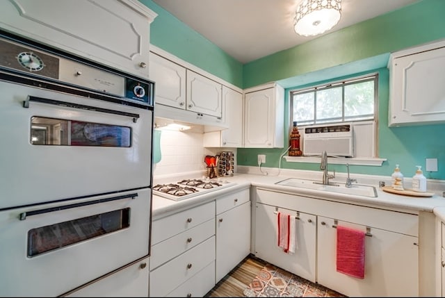 600 Liddon Unit 78, Midland, TX 79705 - kitchen featuring white appliances, a sink, white cabinetry, light countertops, and decorative backsplash